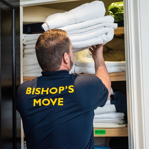 Bishop's Move employee placing towels onto a shelf