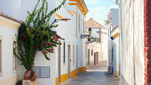Quaint white and yellow buildings in the cobbled streets of Faro, Portugal
