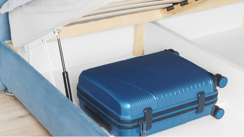 Blue suitcase stored under a blue lift-top bed frame with the top up