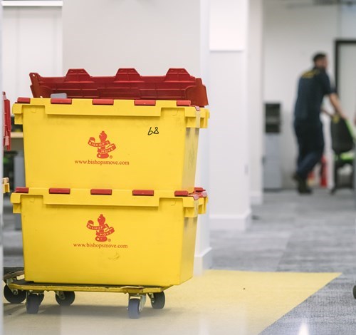 Yellow Bishop’s Move storage boxes stacked on a trolley