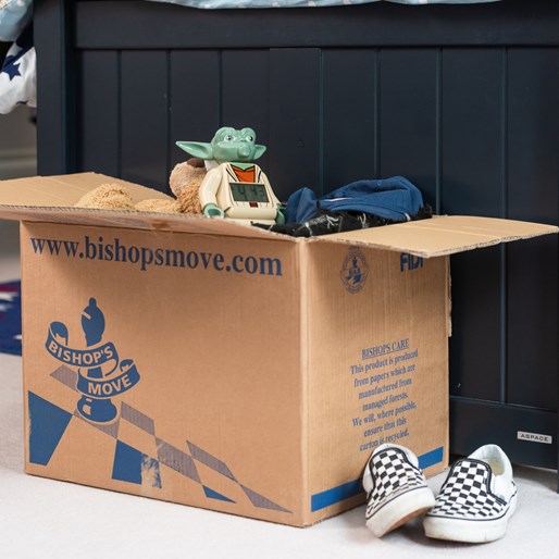 A Bishop's Move carboard box with toys inside