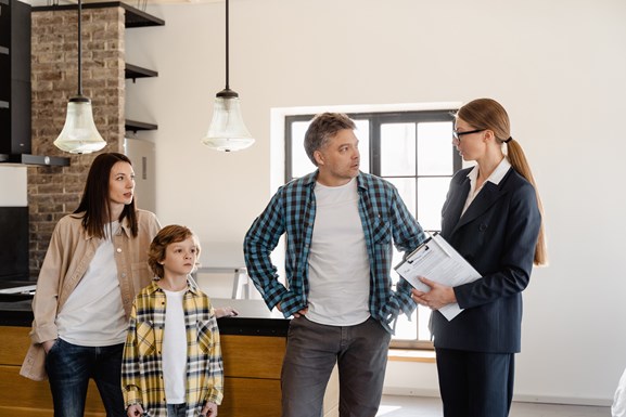 Family talking to a real estate agent on a house viewing in a decluttered home.