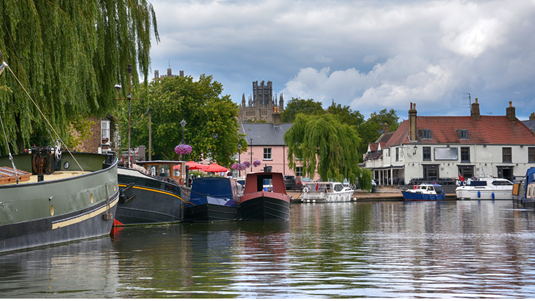 Boats on a river in Ely, Cambridgeshire.