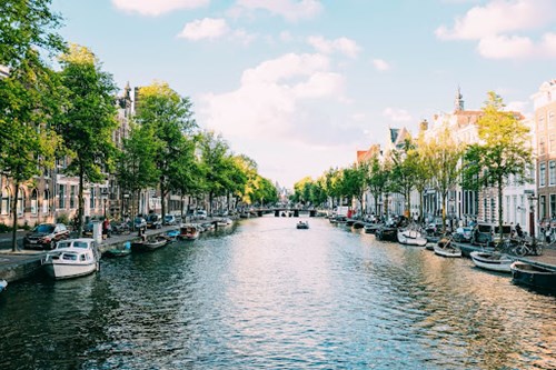 Canal lined with boats and trees, Amsterdam, Netherlands