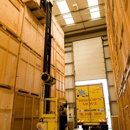 Rear end of Bishop’s Move removal van through a warehouse storage door.