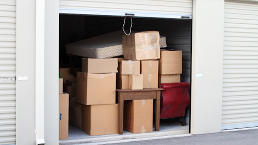White storage unit with cardboard boxes stacked up inside