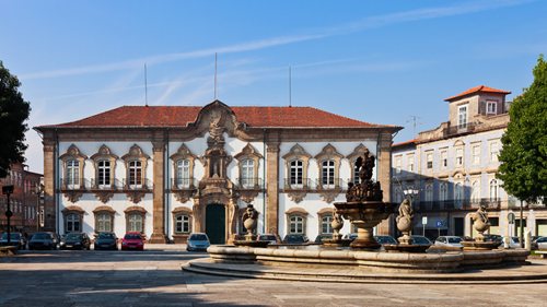 Town Hall, Braga, in the sunshine with cars parked outside