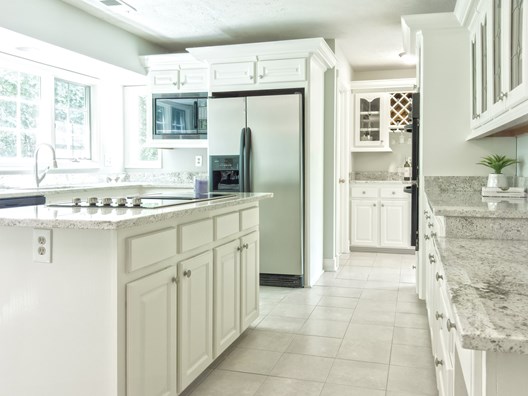 Clean white kitchen with marble surfaces
