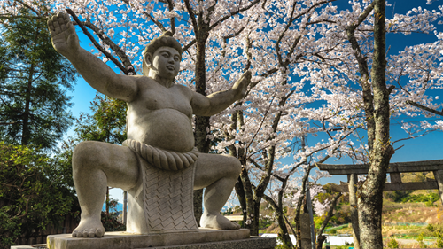 Stone statue of a Sumo wrestler in Japan on a clear day