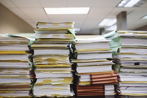 Stacks of paperwork marked with post-it notes