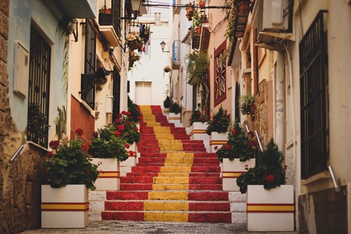 Steps painted with the Spanish flag leading through an old town
