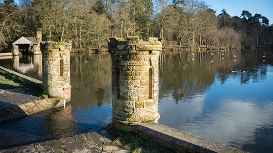 Picturesque structures on the edge of a lake in Buchan Country Park on the outskirts of Crawley.